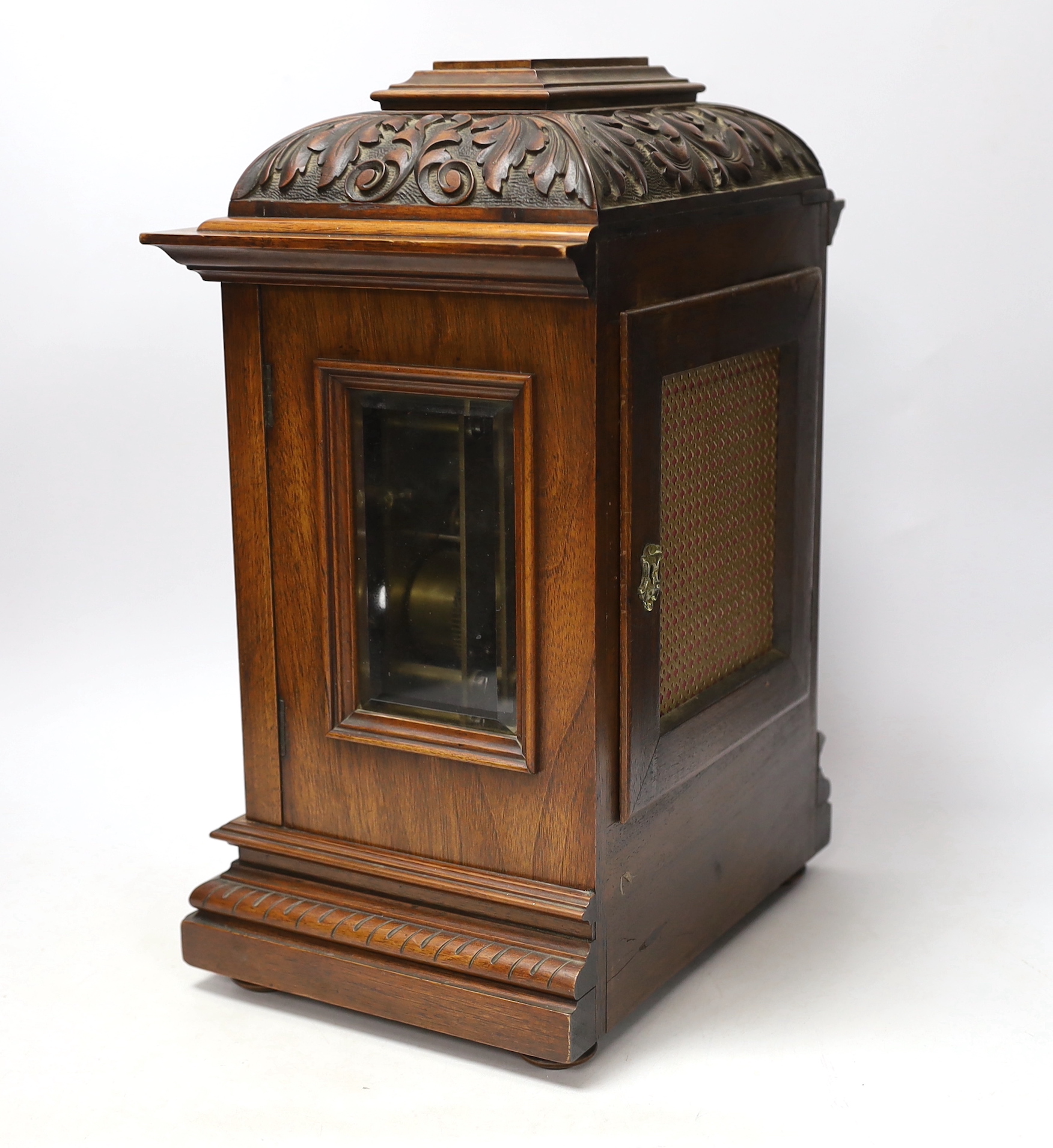A carved walnut mantel clock with German movement, 36cm